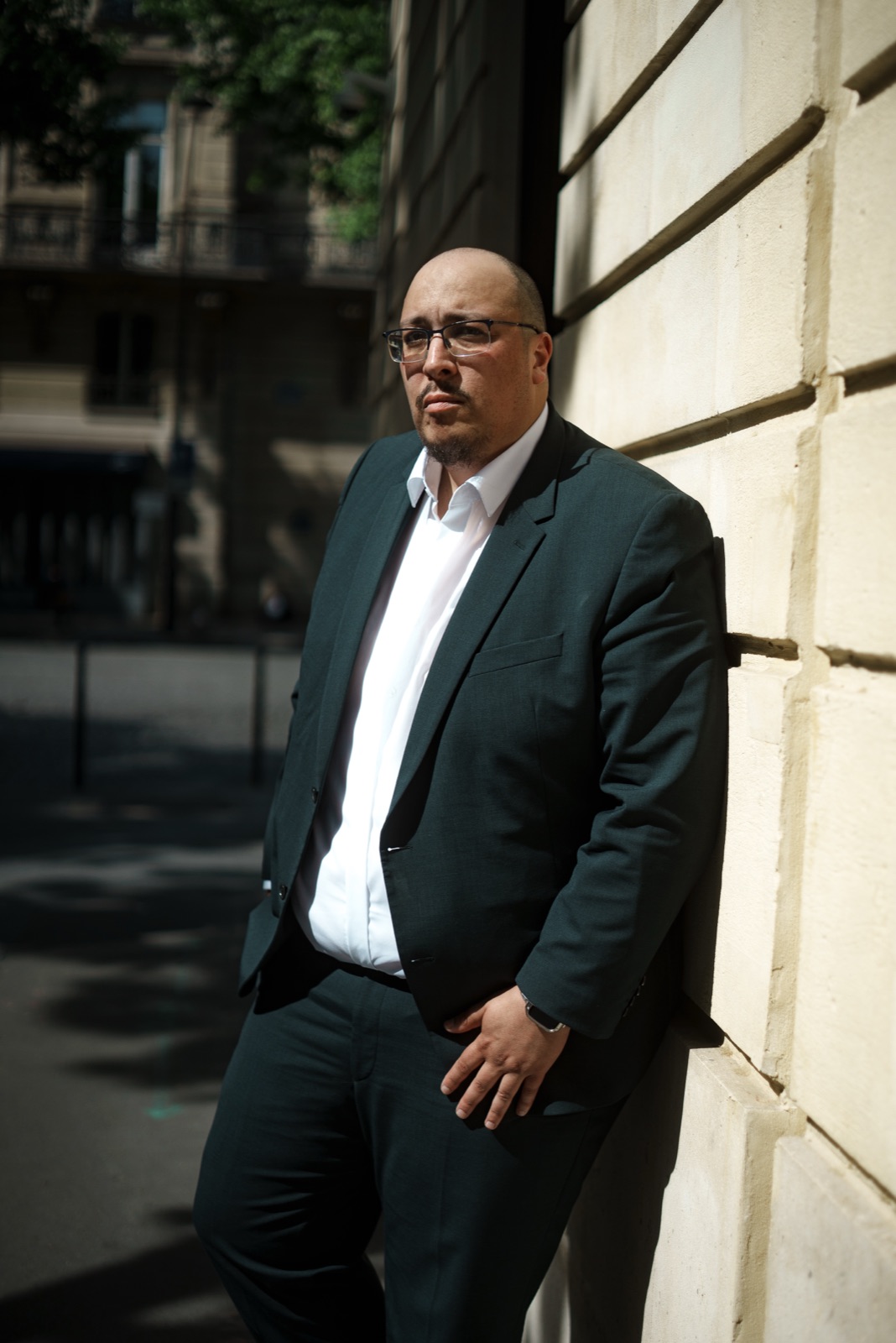 Ali Bekour, adossé à un mur de pierre, regard frontal